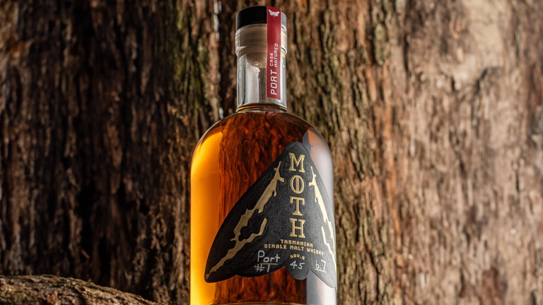 Bottle of Moth whiskey against a wooden background